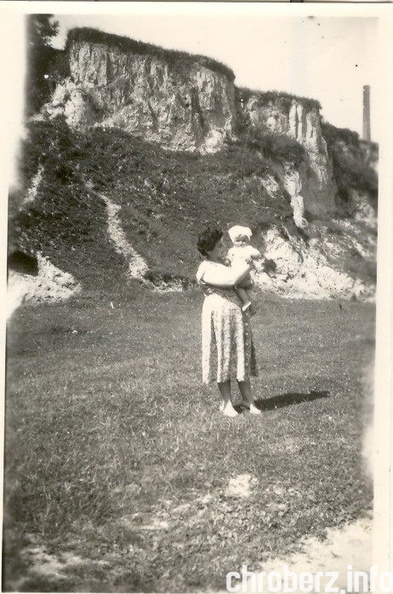 Chroberz, około 1958 roku. Zdjęcie wykonane na tzw. Olszyku. W tle w prawym rogu zdjęcia widać komin gorzelni. Za plecami fotografowanych skarpa (obecnie zakrzaczona i zadrzewiona, w której znajdowały się jaskółcze gniazda). Na zdjęciu Krystyna Piękoś (Małaszyńska),na rękach trzyma córkę Teresę. (arch. Teresa Spychała). 11145934_10204176297428760_1893873107_n.jpg